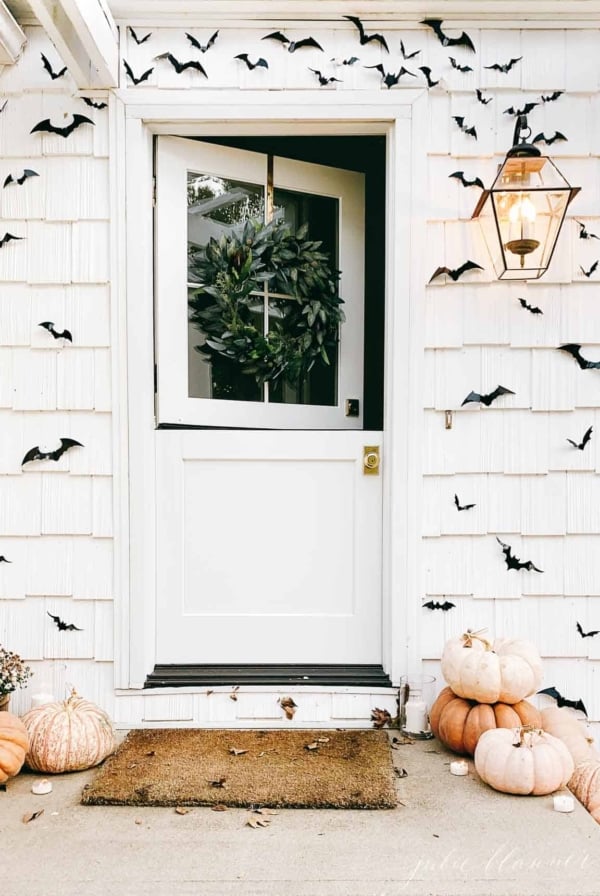 open dutch door surrounded by black bats and pumpkins