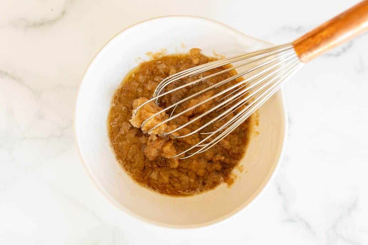 A white bowl full of pumpkin cheesecake bread batter.