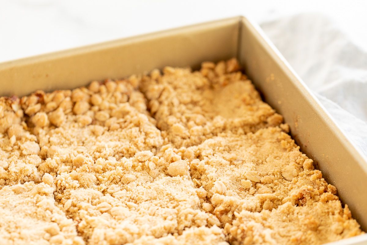 Caramel oatmeal chocolate chip bars baked in a gold baking pan, sliced for serving.