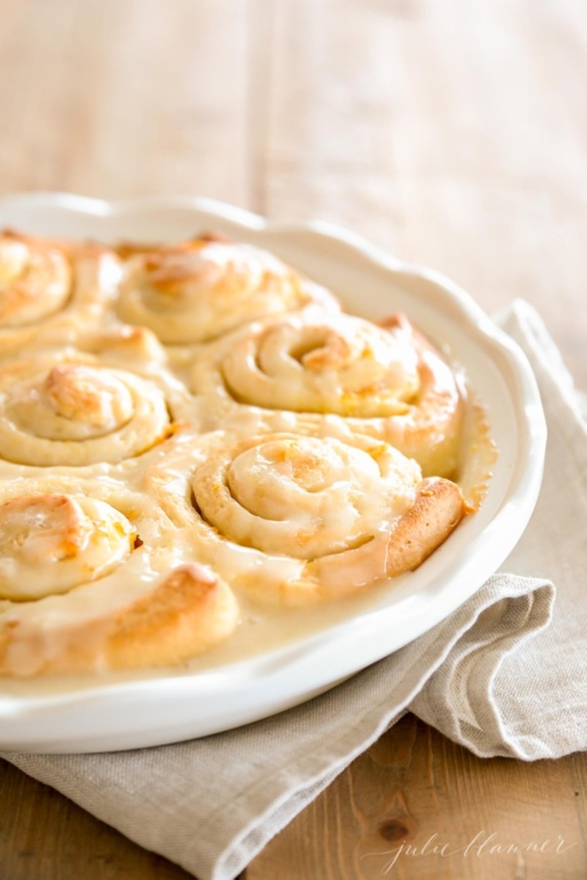 Orange rolls baked into a white ceramic round dish.