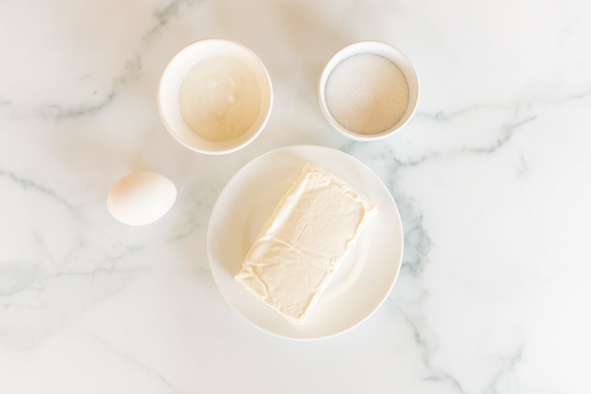 Cheesecake filling ingredients laid out on a marble countertop.