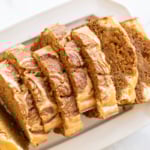 A loaf of pumpkin cheesecake bread on a white platter.