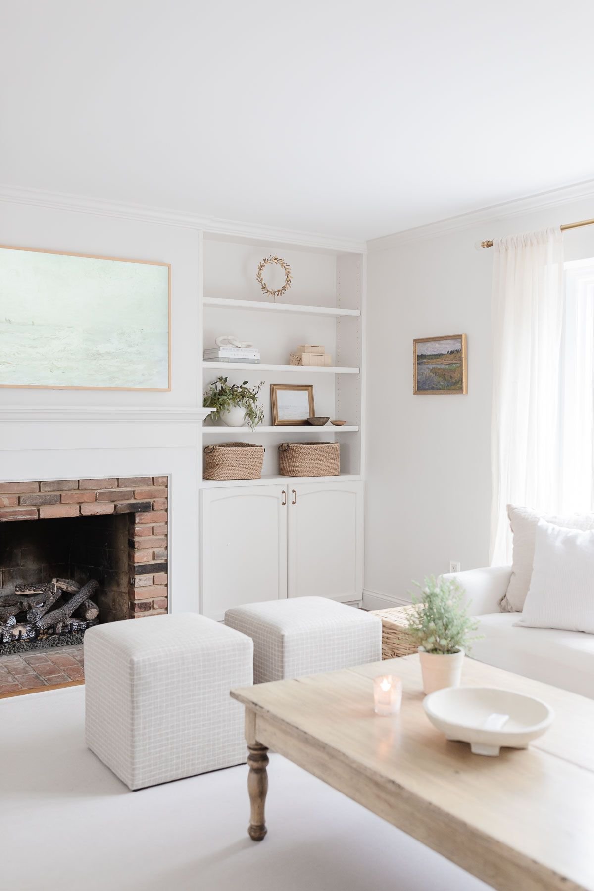 A white living room with a white rug and wood coffee table