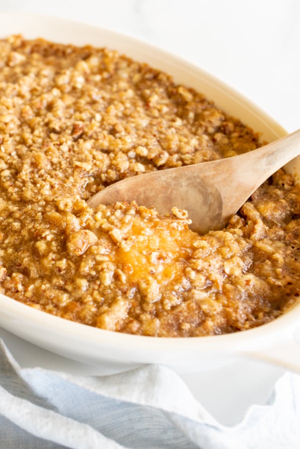 A white oval baking dish full of sweet potato casserole.