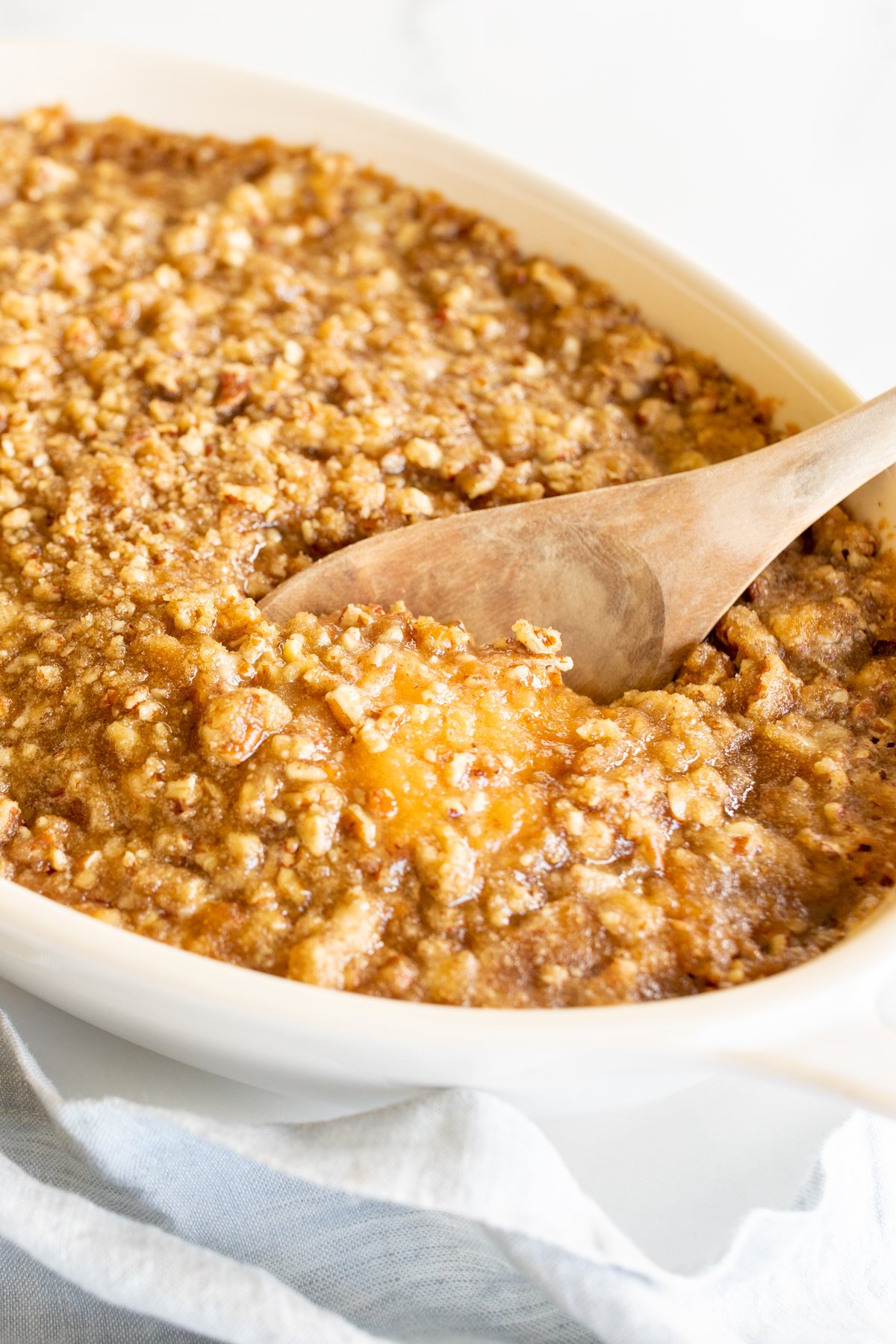 A white oval baking dish full of sweet potato casserole. 