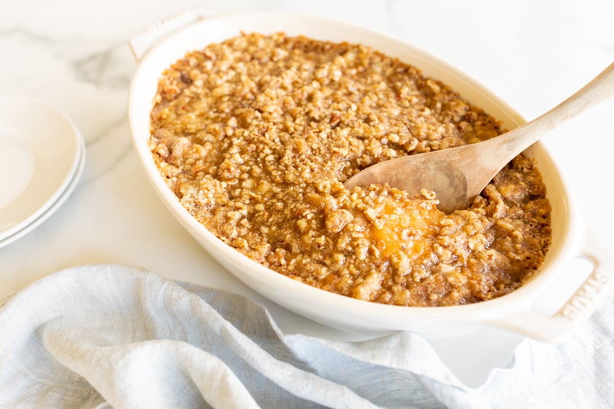 A white oval baking dish full of sweet potato casserole.