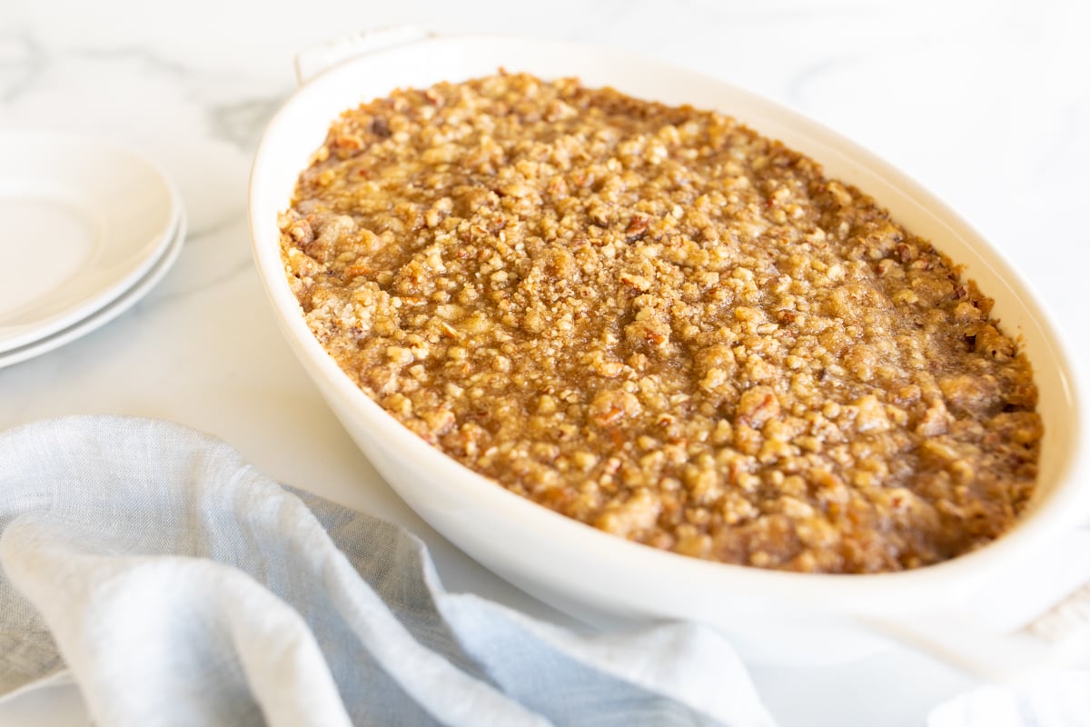 A white oval baking dish full of sweet potato casserole.