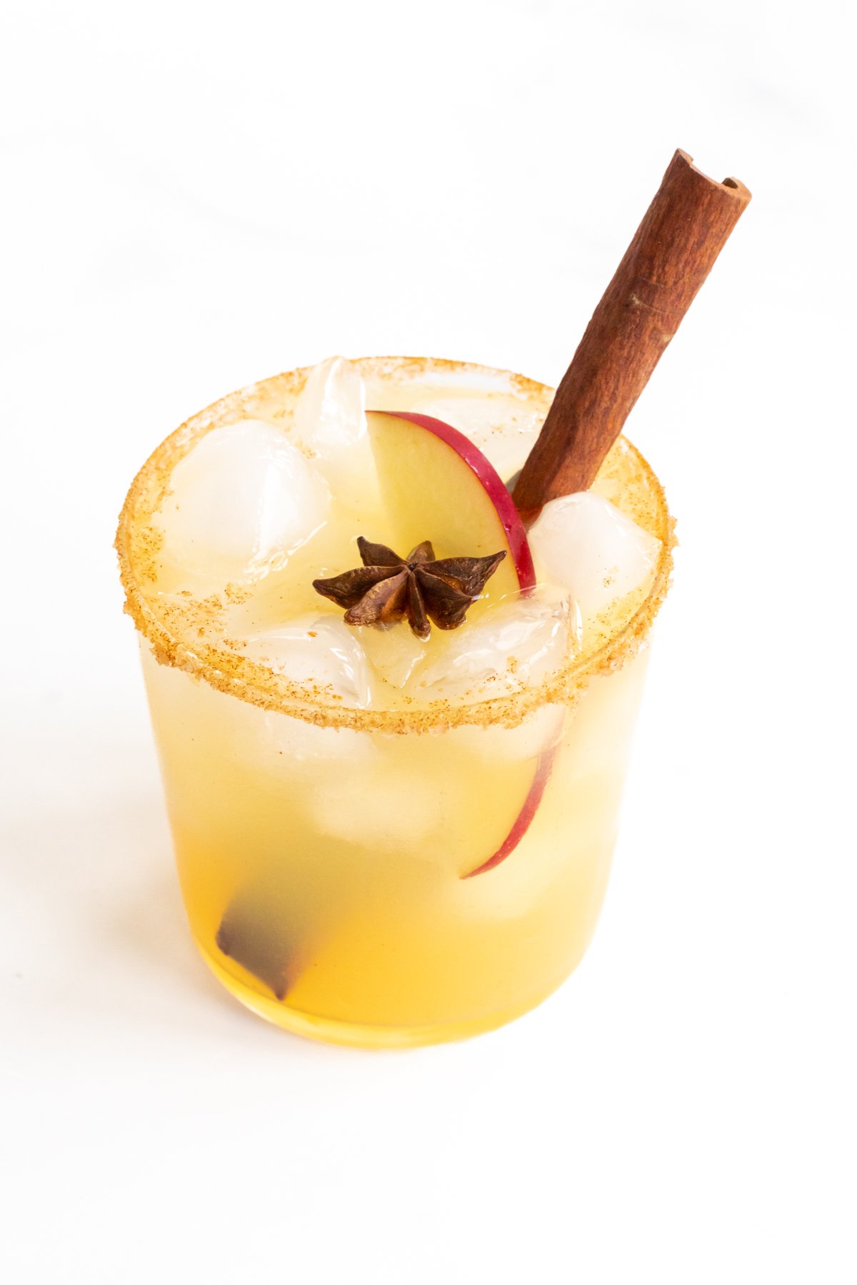 An apple cider margarita garnished with a cinnamon stick.