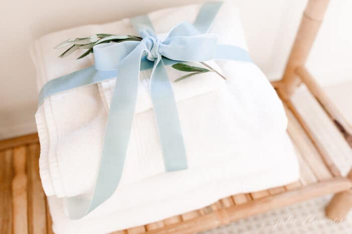 White towels in a guest room, tied in a blue velvet bow for a Scandinavian Christmas touch.