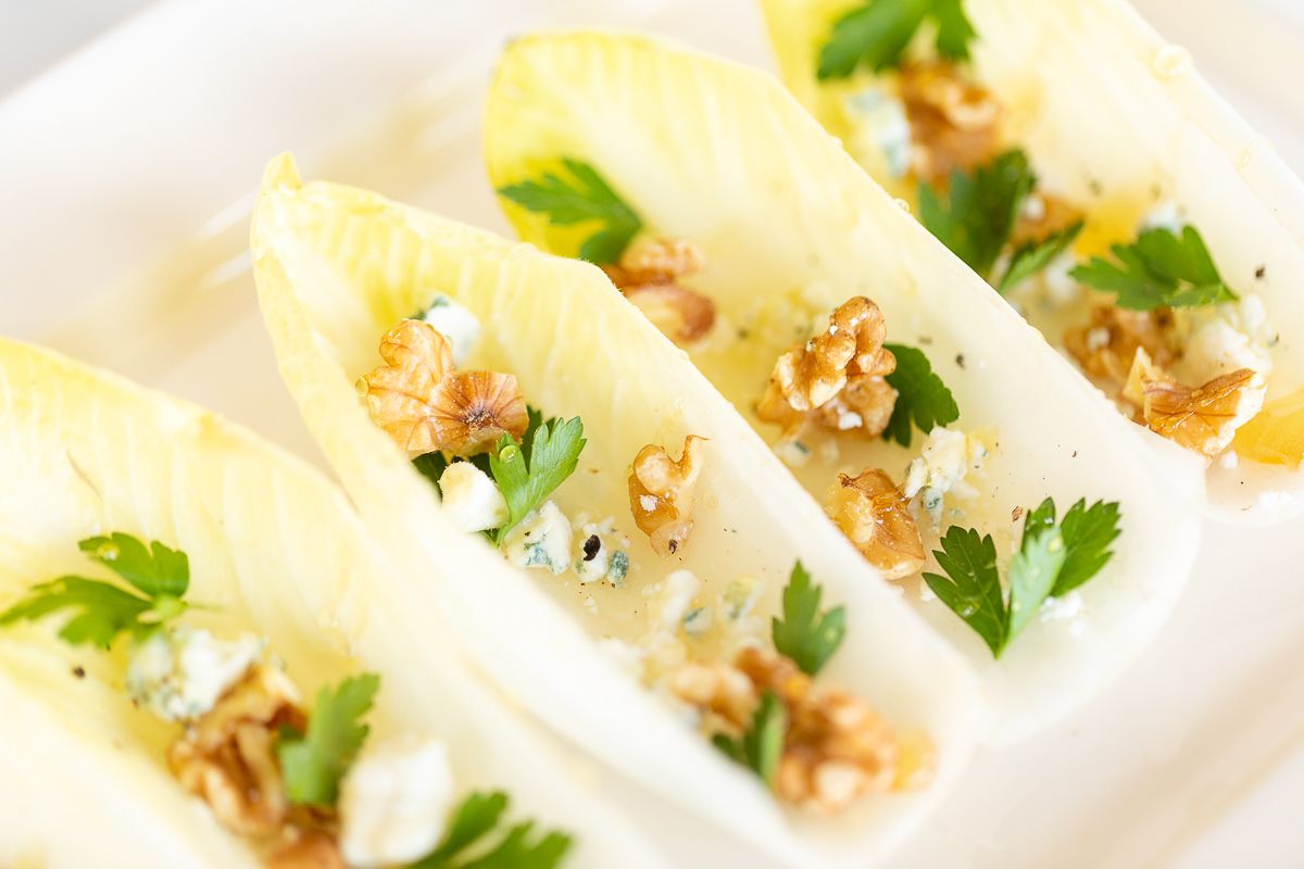 An endive salad laid out on a white platter.