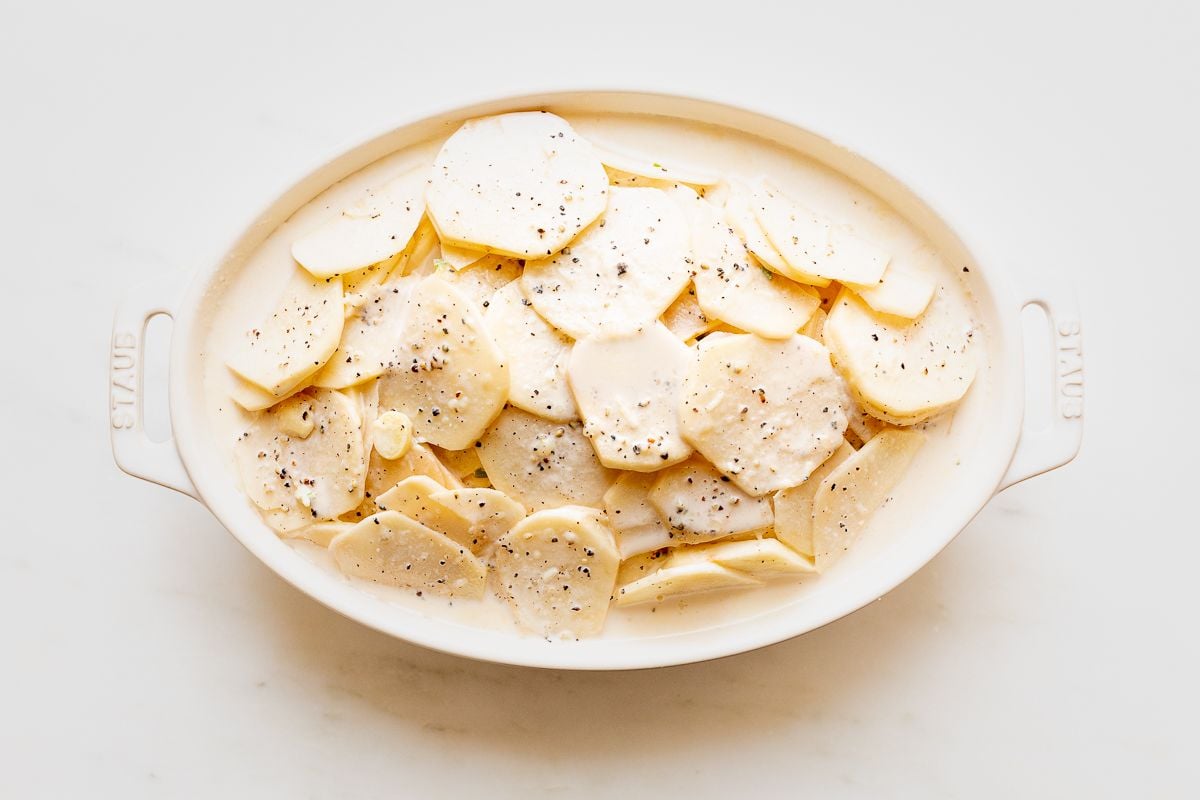 Gratin Dauphinoise potatoes in a white oval baking dish.