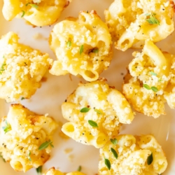 A platter full of mini mac and cheese cups for an appetizer.