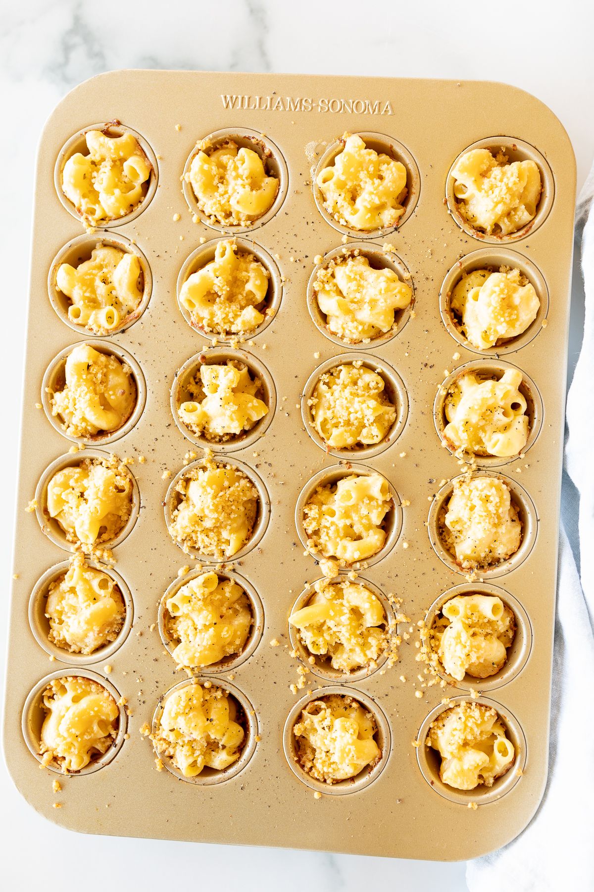 A mini muffin tin filled with mac and cheese cups.