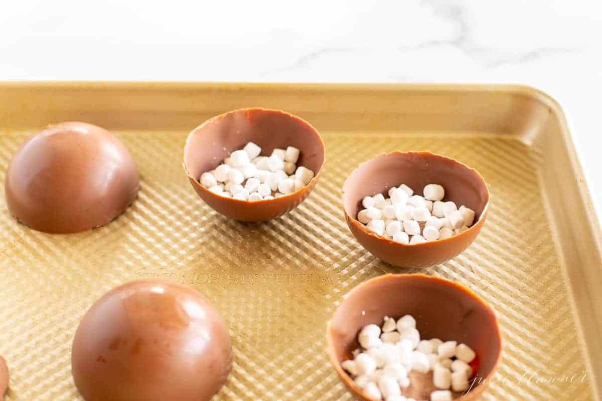 A gold tray with half spheres of Mexican hot chocolate bombs