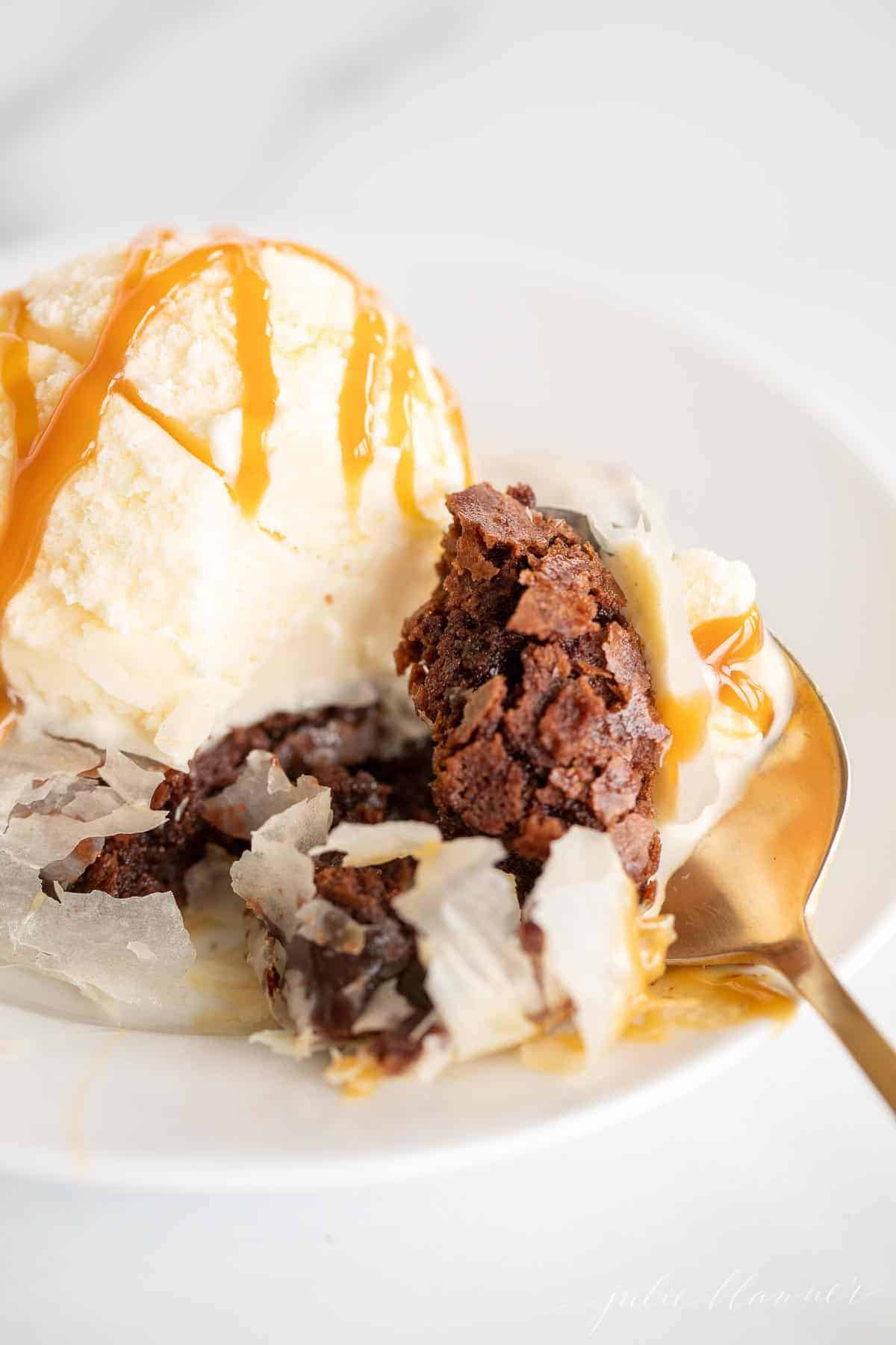 brownie on plate with gold spoon