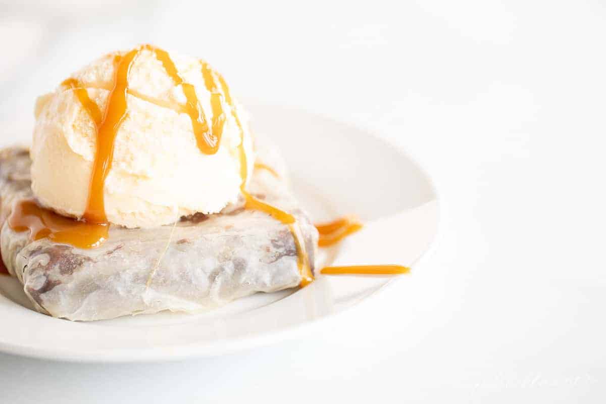 phyllo dessert with ice cream and caramel sauce on white plate