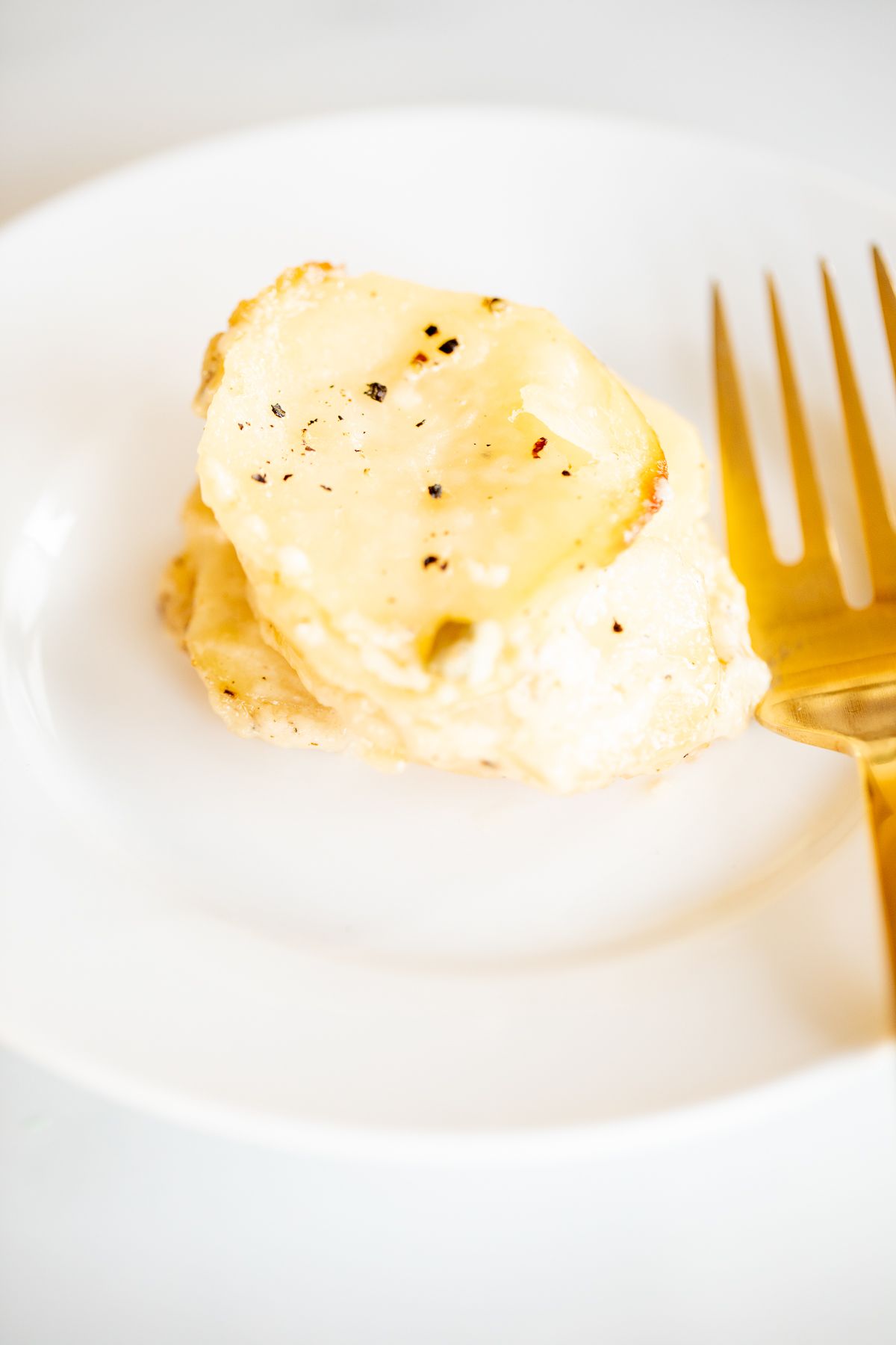 A white plate featuring potato gratin stacks.