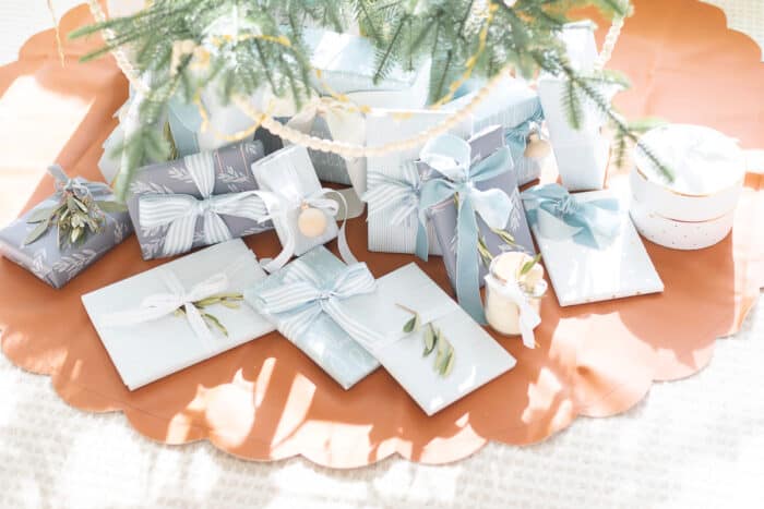 Blue and white gifts wrapped underneath a Scandinavian tree.