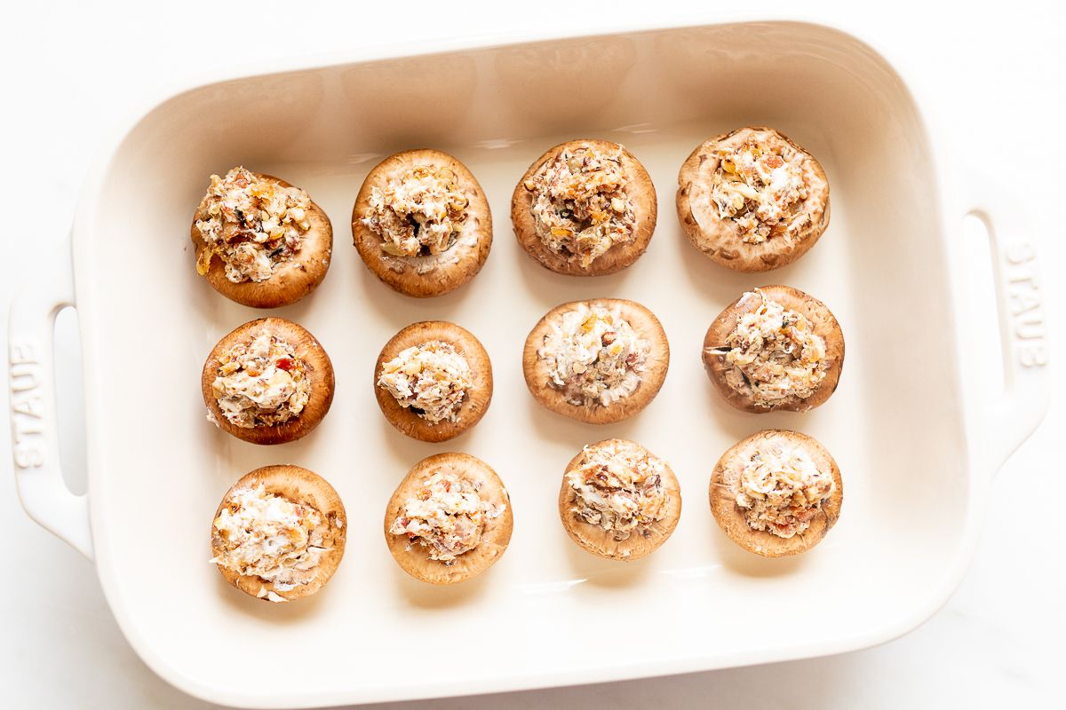 Cream cheese and bacon stuffed mushrooms in a white baking dish