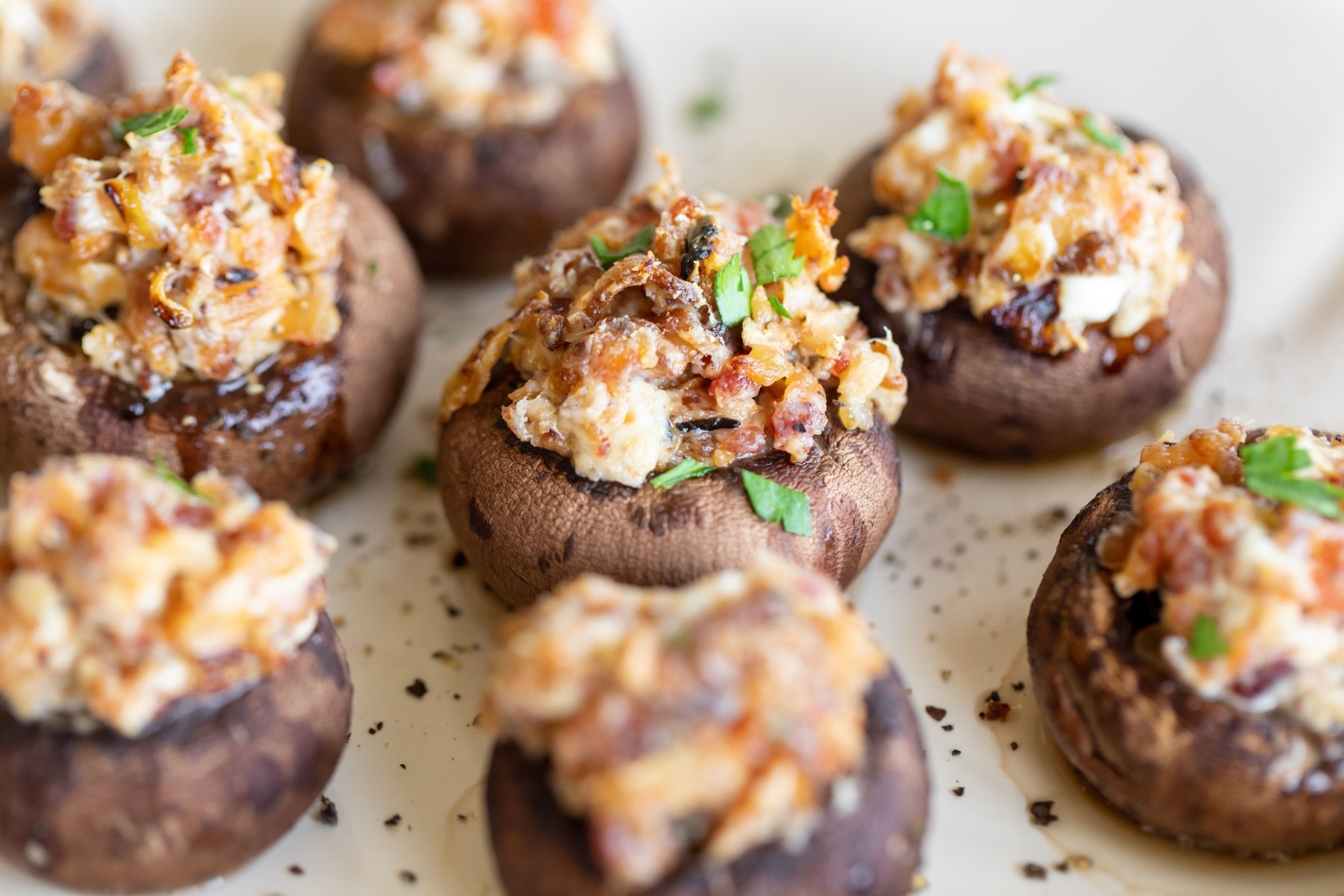 An oval white platter filled with bacon stuffed mushrooms