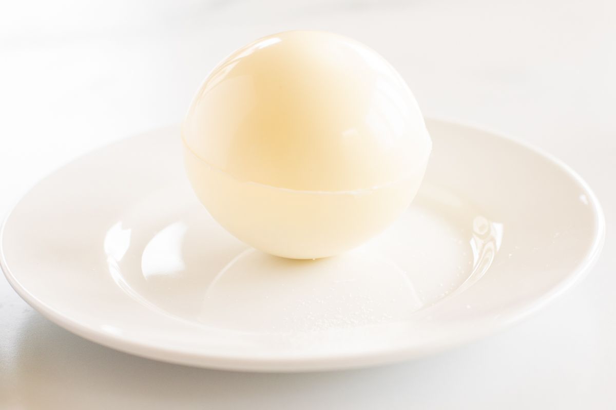 white chocolate hot cocoa bomb on a white plate