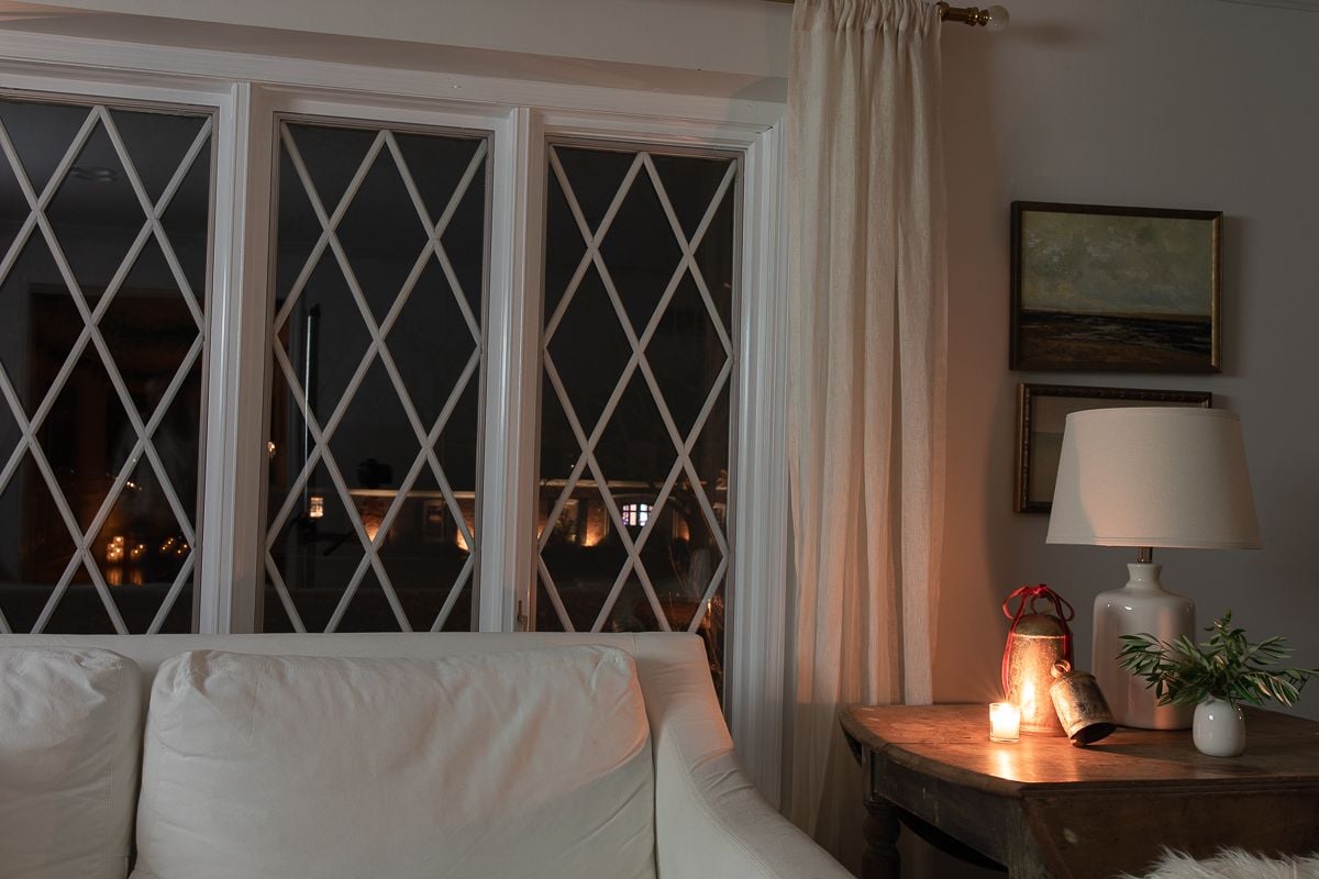 A white living room with candles and brass bells on the table for Christmas