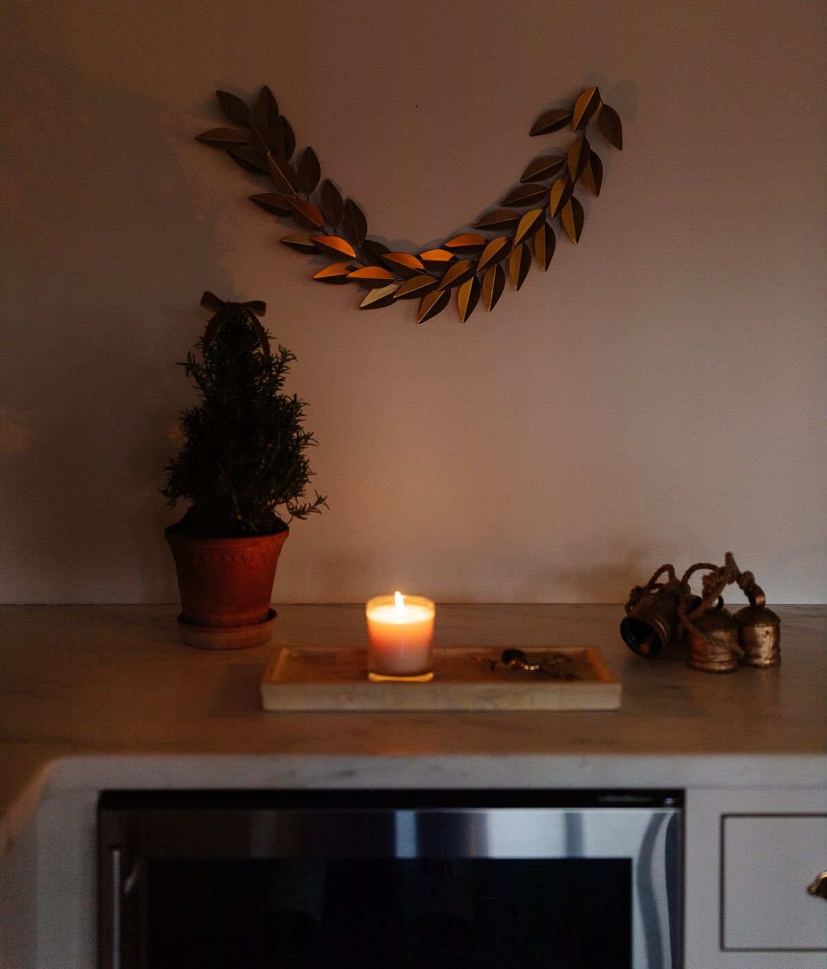 A corner of a white kitchen with Christmas decorations at night