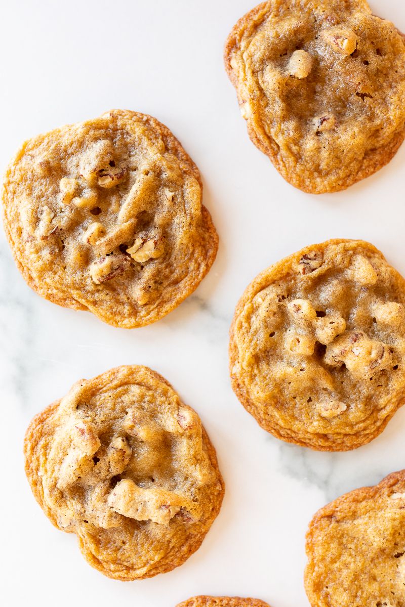 Pecan pie cookies laid out on a white surface.