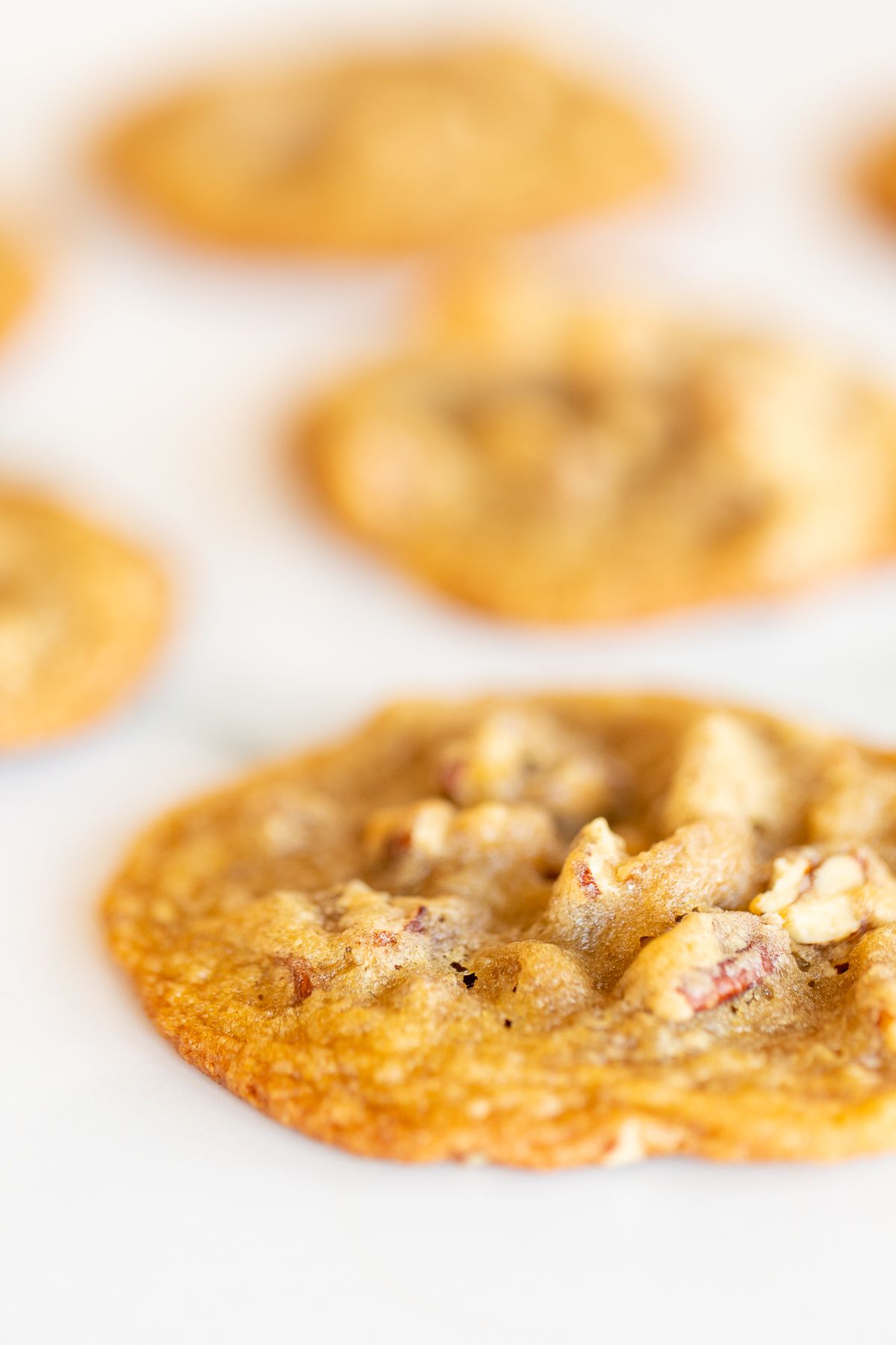 Pecan pie cookies laid out on a white surface.