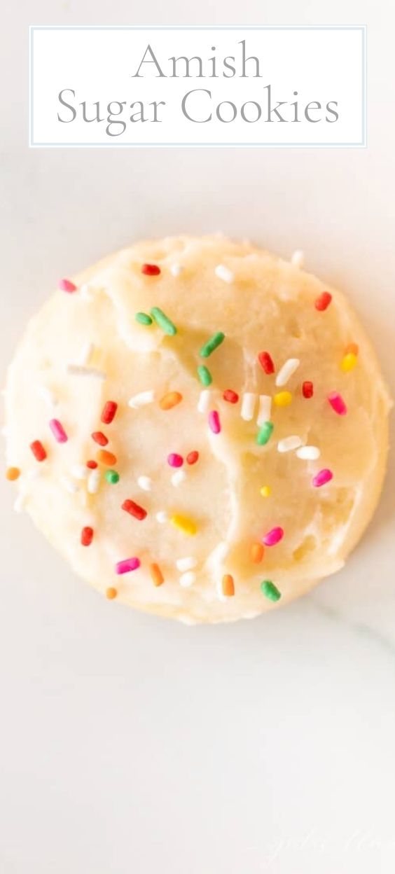 A single melt in your mouth sugar cookie frosted with sprinkles on a marble surface.