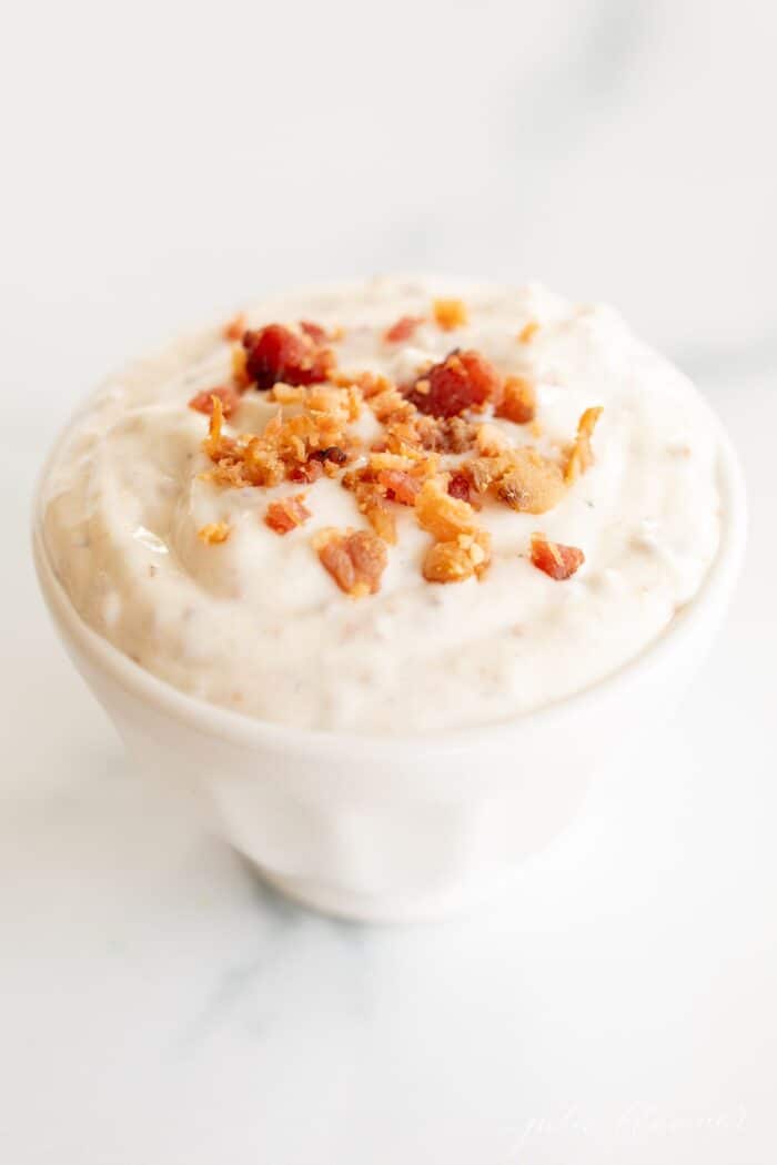 Bacon aioli in a small white bowl on a marble surface.