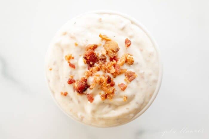 Bacon aioli in a small white bowl on a marble surface.