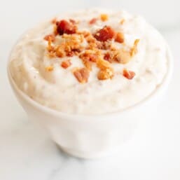 Bacon aioli in a small white bowl on a marble surface.