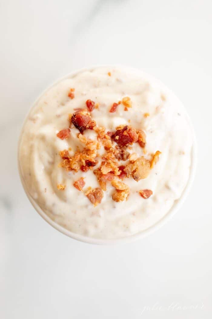 Bacon aioli in a small white bowl on a marble surface.