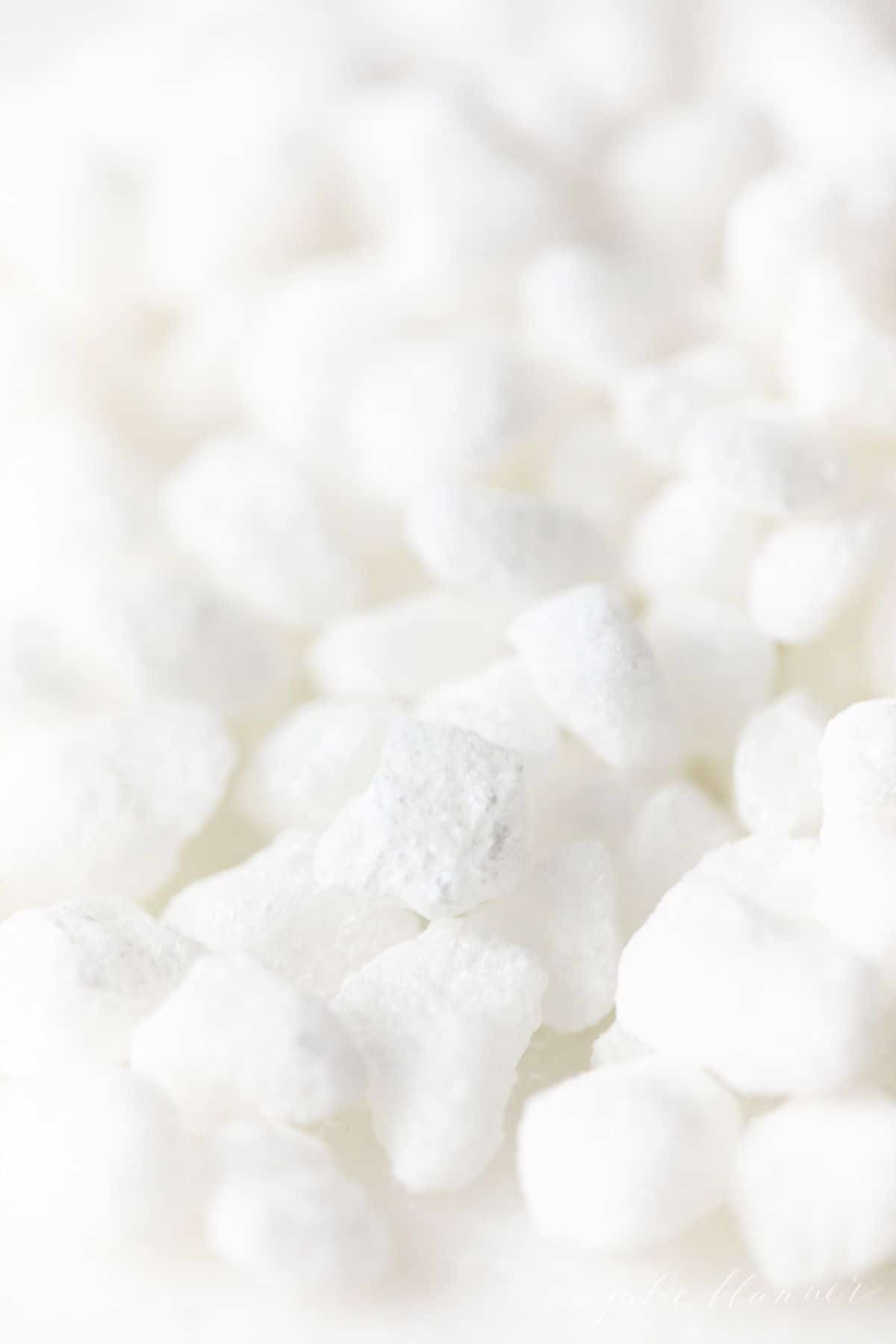 Belgian pearl sugar nibs scattered on a white surface.