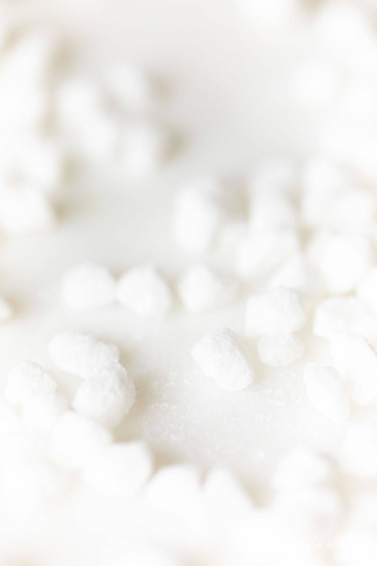 Belgian pearl sugar nibs scattered on a white surface.