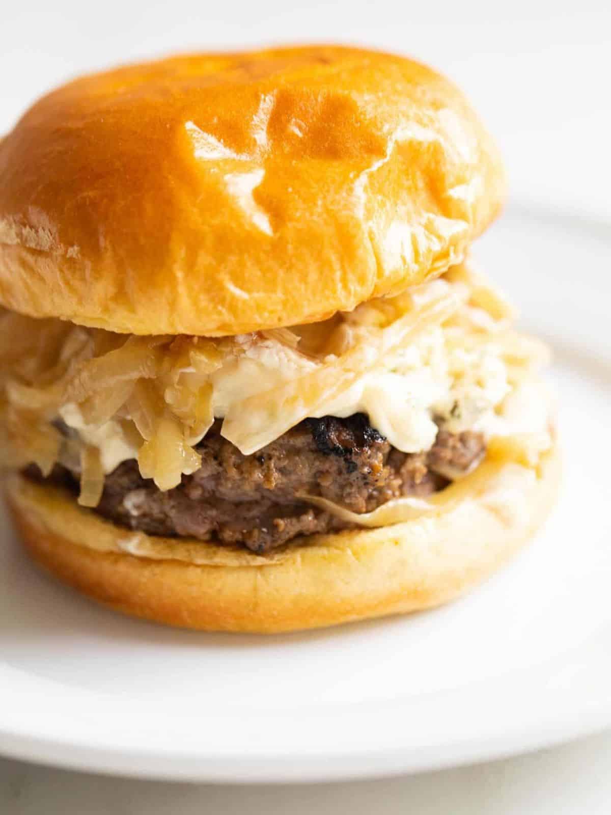 juicy burger on a brioche bun topped with aioli caramelized onion and boursin