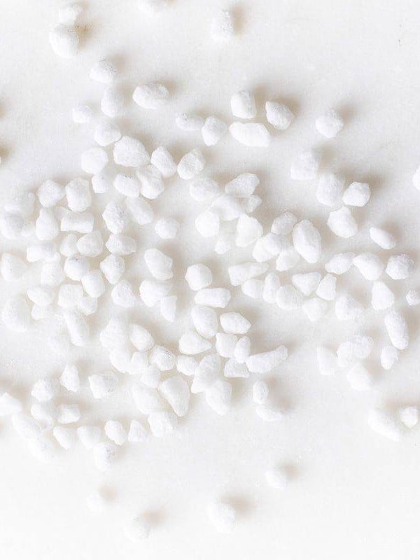 Belgian pearl sugar nibs scattered on a white surface.