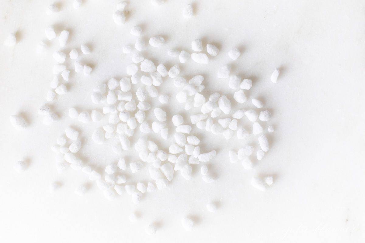 Belgian pearl sugar nibs scattered on a white surface.