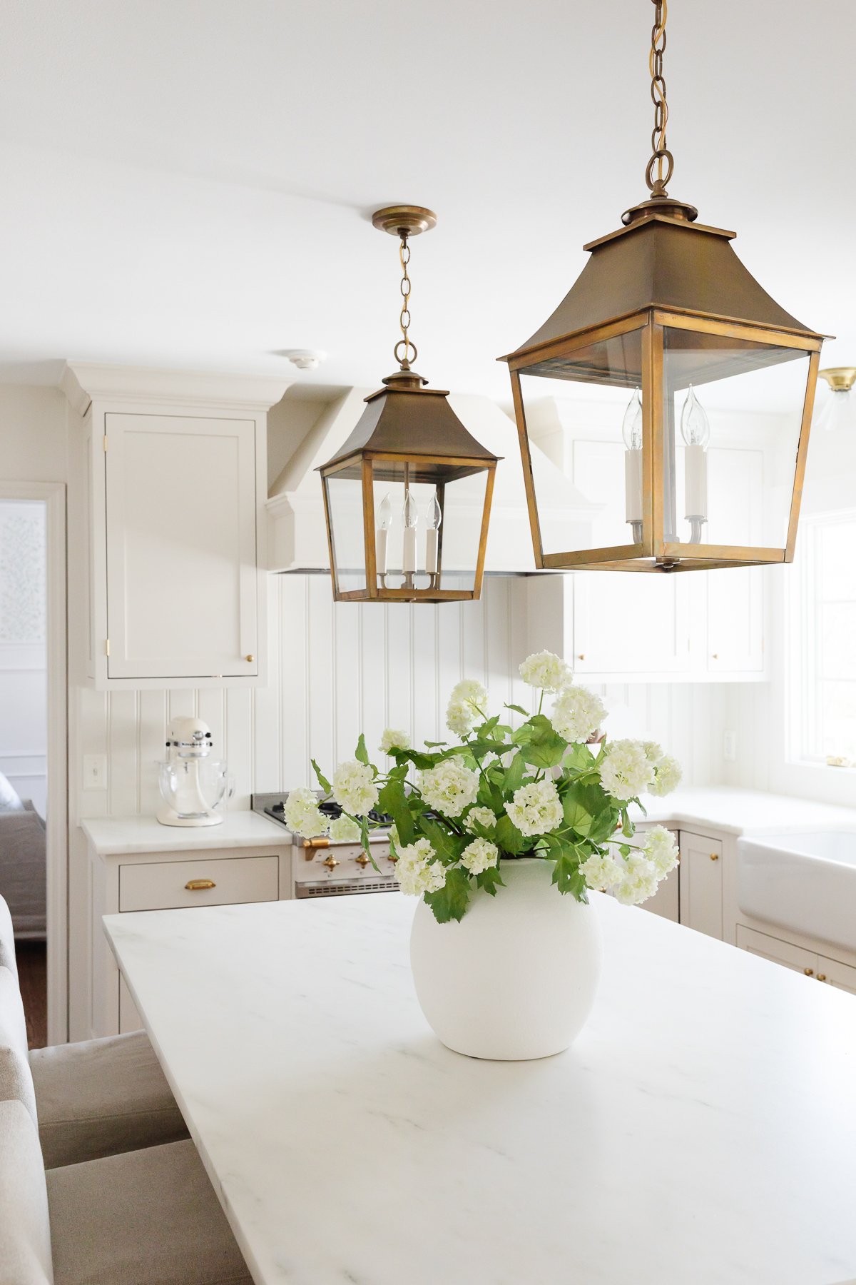 A cream kitchen with inset cabinets and a wood island.