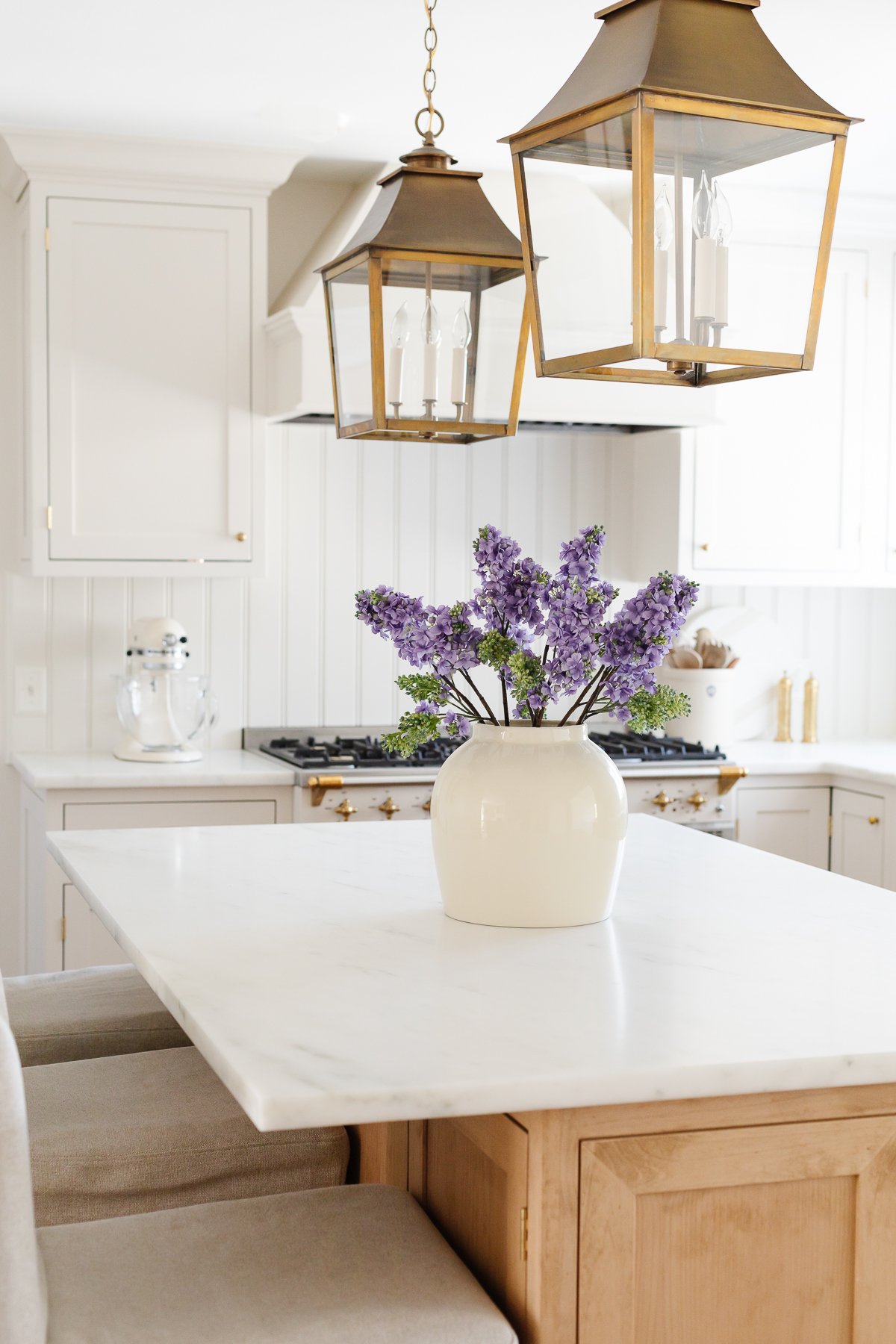 A cream kitchen with inset cabinets and a wood island.