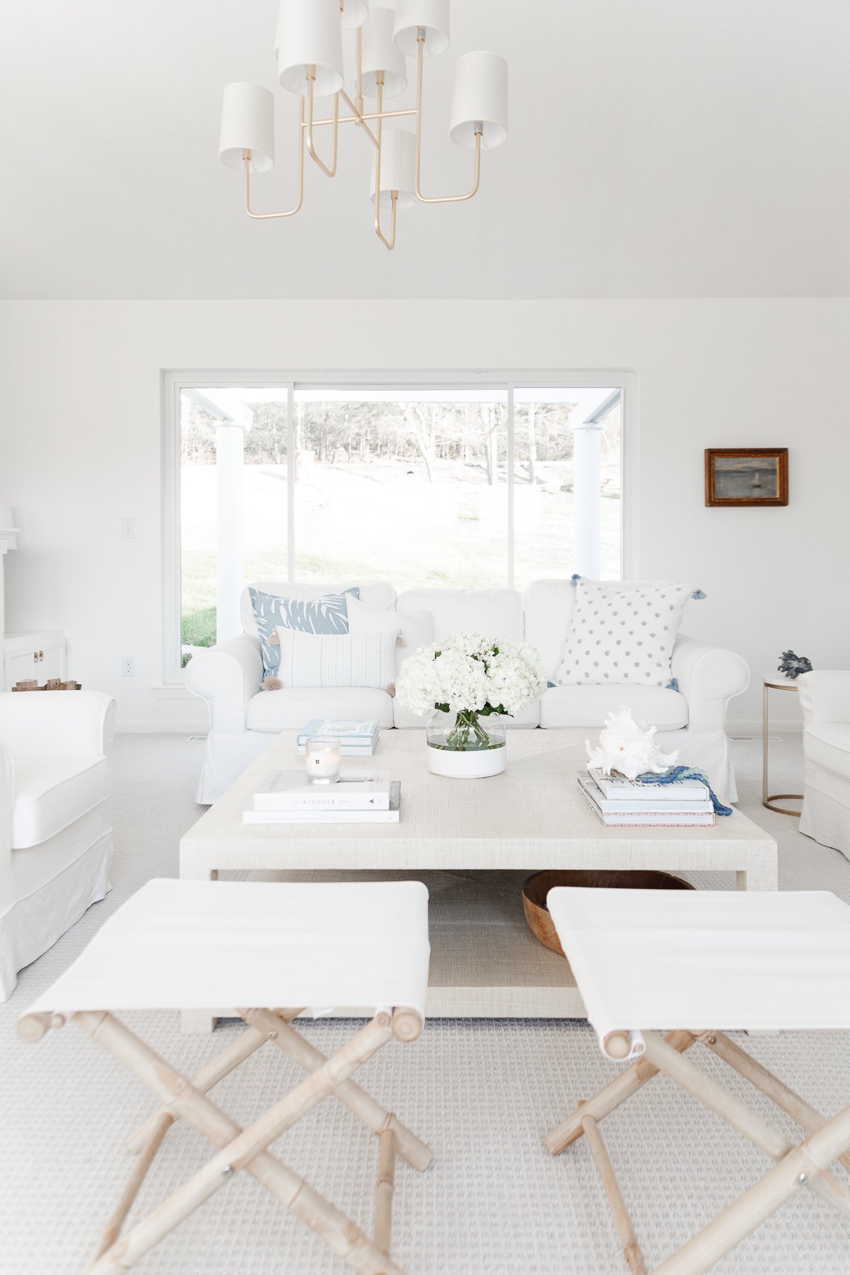 A white living room with blue accents in a guide to minimalist lifestyle.