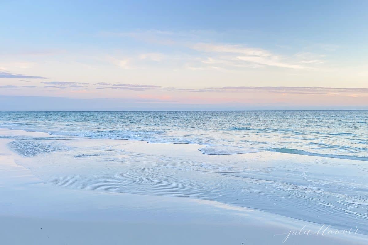 A blue and pale pink beach sunset scene