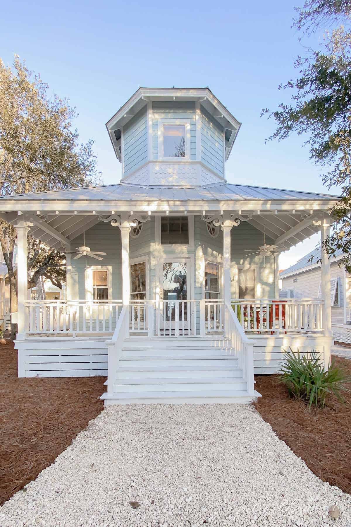 A charming pale blue beach house with a white front porch in Seaside Florida