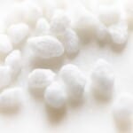 pearl sugar nibs scattered on a white surface.