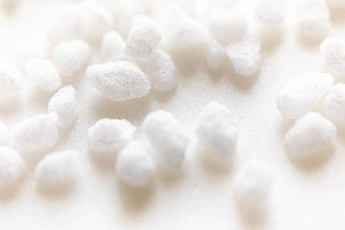 Swedish pearl sugar nibs scattered on a white surface.