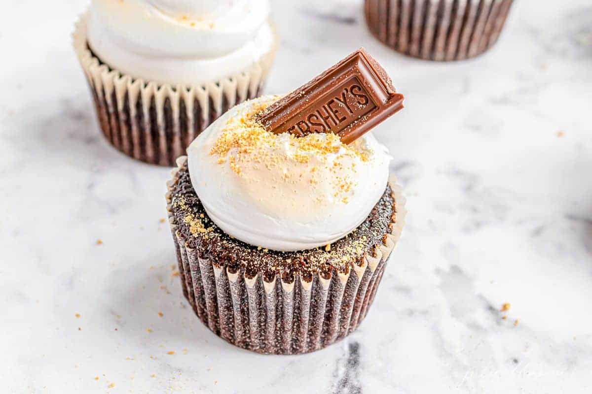 S'mores cupcakes on a marble surface.