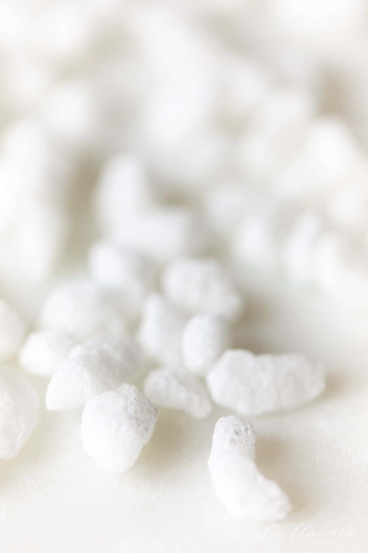 Swedish pearl sugar nibs scattered on a white surface.