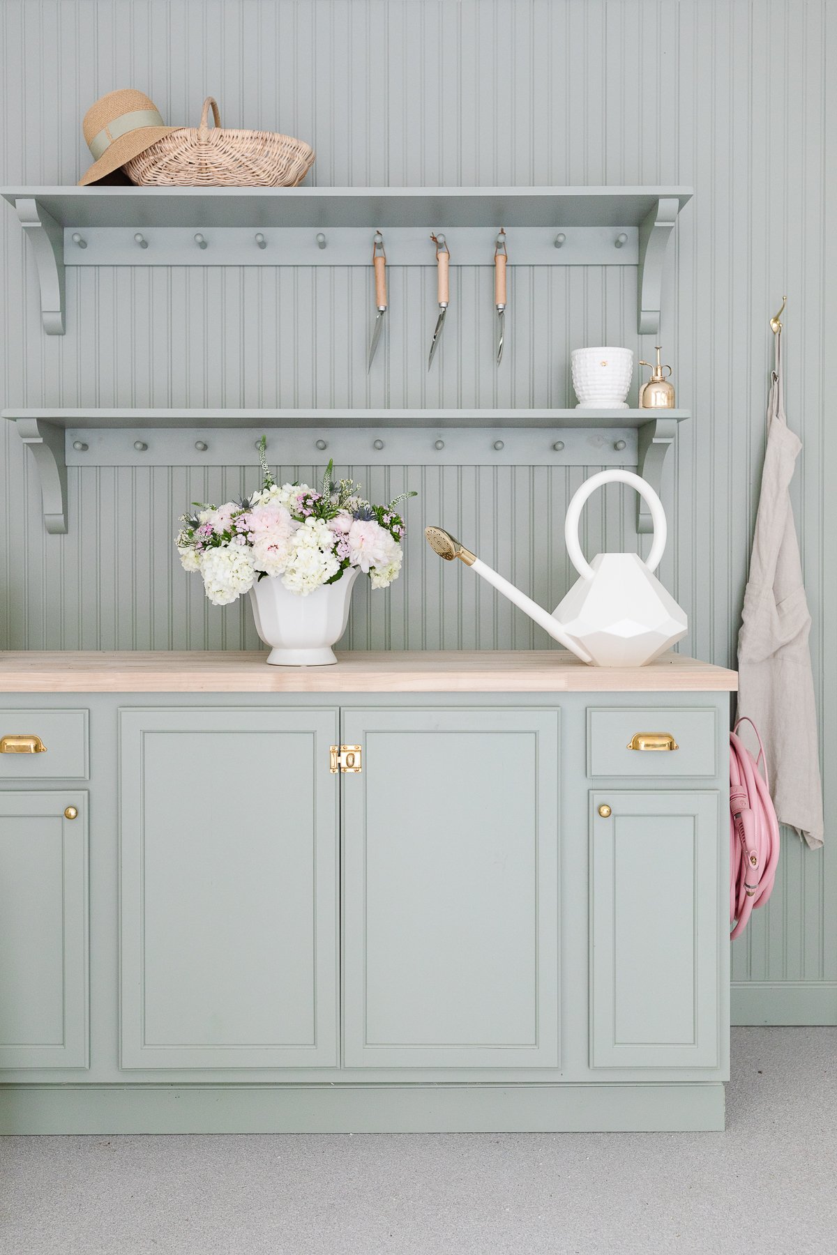 A green potting bench area with beadboard on the walls