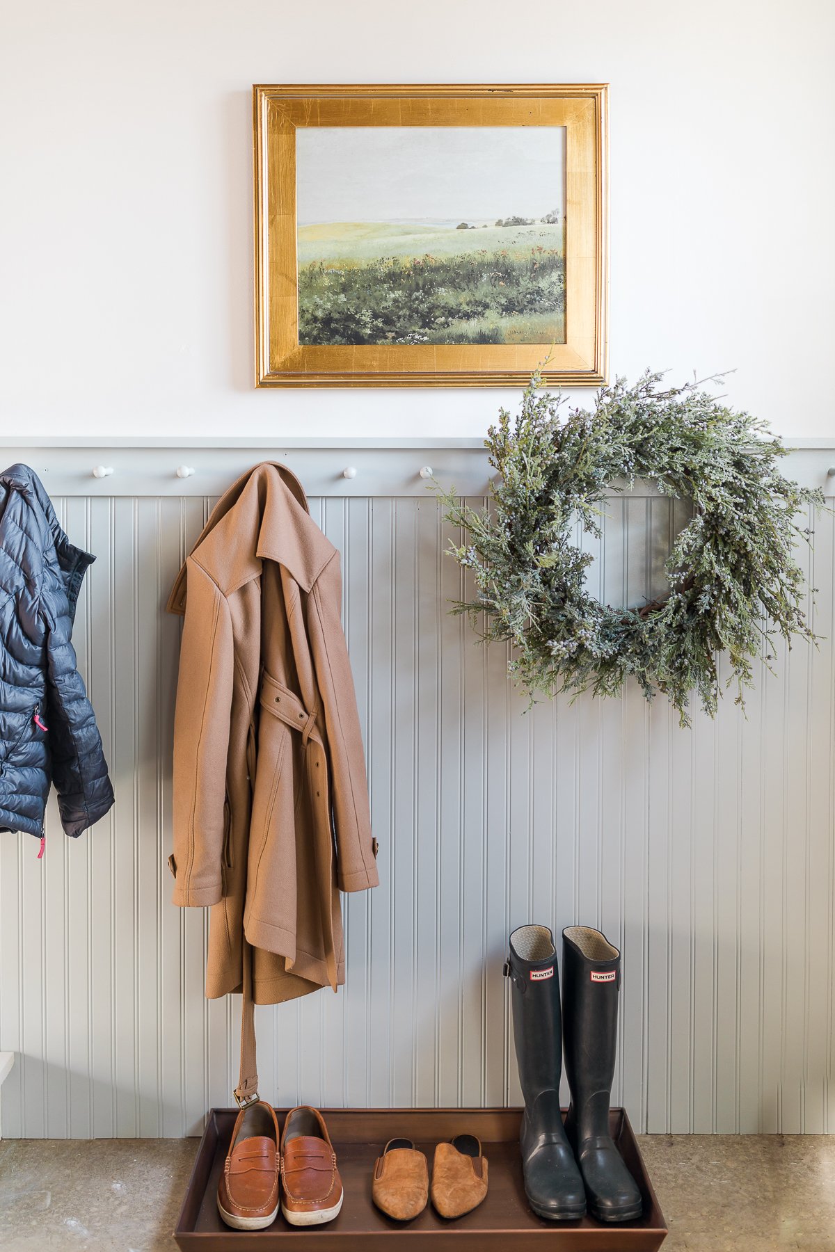 A garage mudroom with beadboard and peg rail painted a soft gray blue.